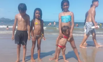 Família que esperou 13 horas em rodoviária para viajar comemora Réveillon na praia: 'Vou comprar passagem de volta mais cedo'