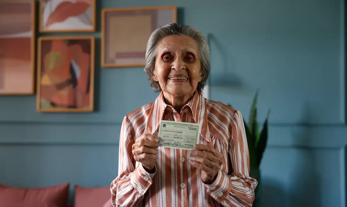 Eleitora idosa exibe título eleitoral. A abstenção entre brasileiros com mais de 70 anos caiu 9,7 pontos percentuais nas eleições de 2026
